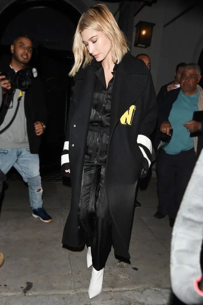 Dê um toque de glamour a um look de athleisure com uns botins brancos de salto alto para uma saída à noite, como fez Hailey Baldwin