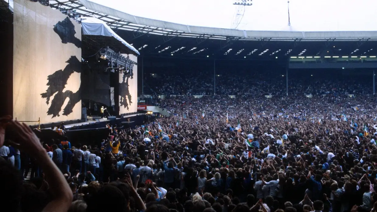 O palco e a plateia de um concerto da digressão de "The Joshua Tree"