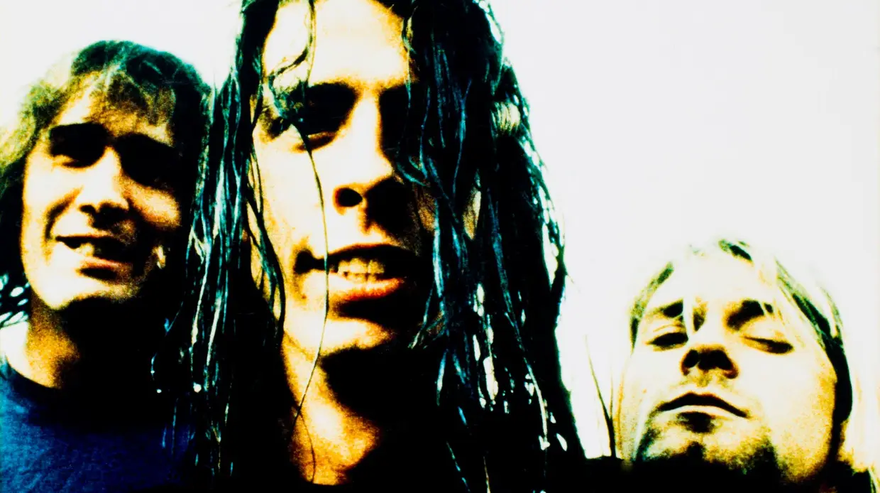 Krist Novoselic, Dave Grohl e Kurt Cobain fotografados durante a digressão de "Nevermind"