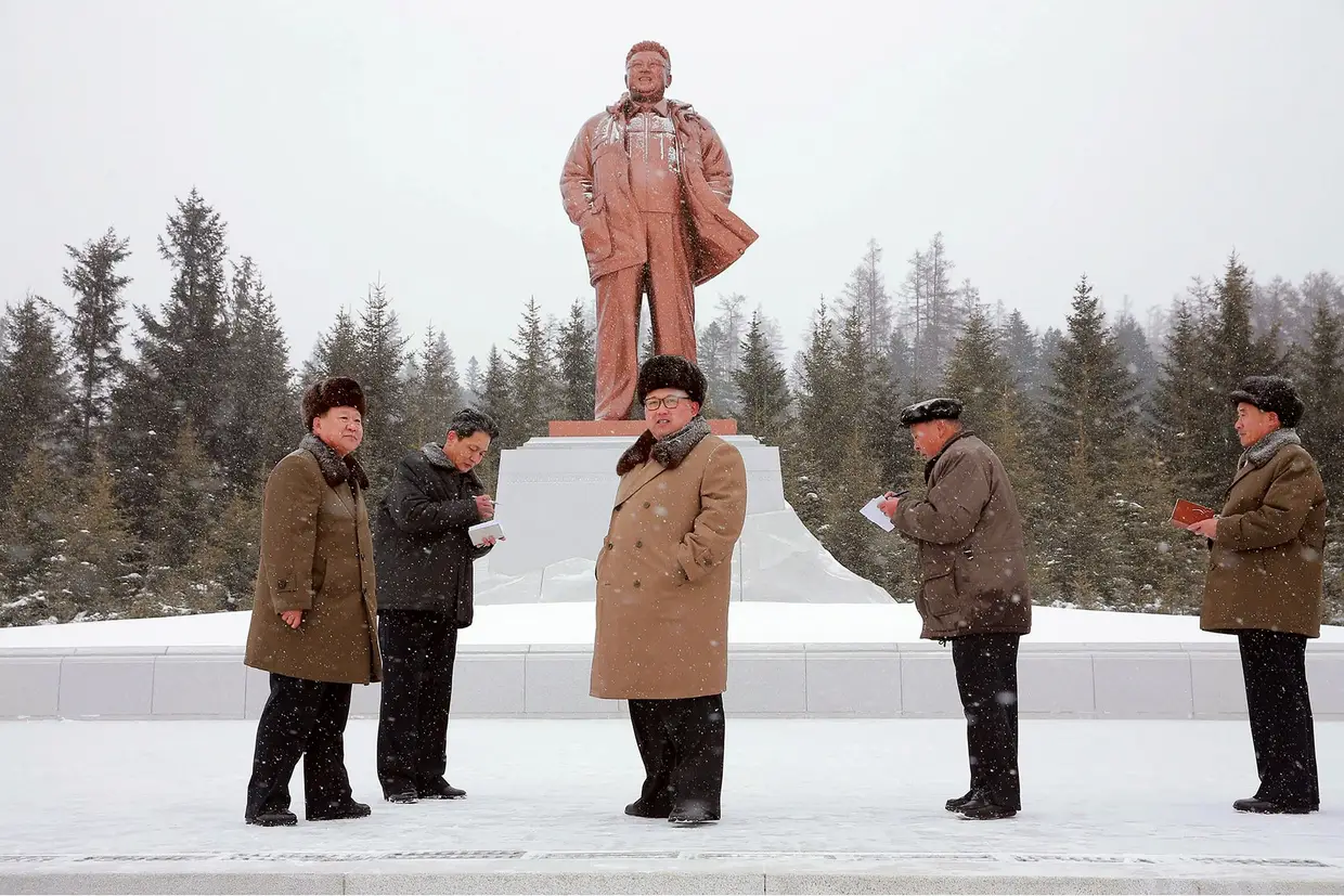   In the snow, in front of the bronze statue from his father, Kim Jong-il, to Samjiyun 