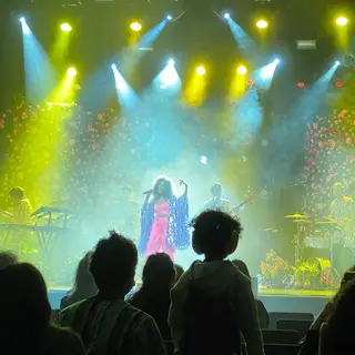 Irma em palco sob o olhar atento do companheiro, Filippo Fiumani, e o filho de ambos, Moa