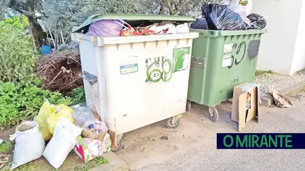 Contentores dos ecopontos vazios, rodeados de cartão, plástico e garrafas Contentores dos ecopontos vazios, rodeados de cartão, plástico e garrafas