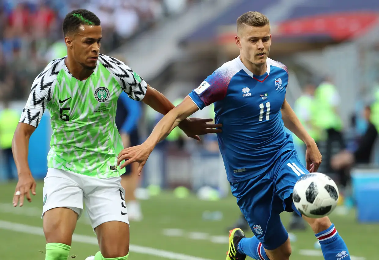 Nigeriano William Ekong e islandês Alfred Finnbogason disputam a bola