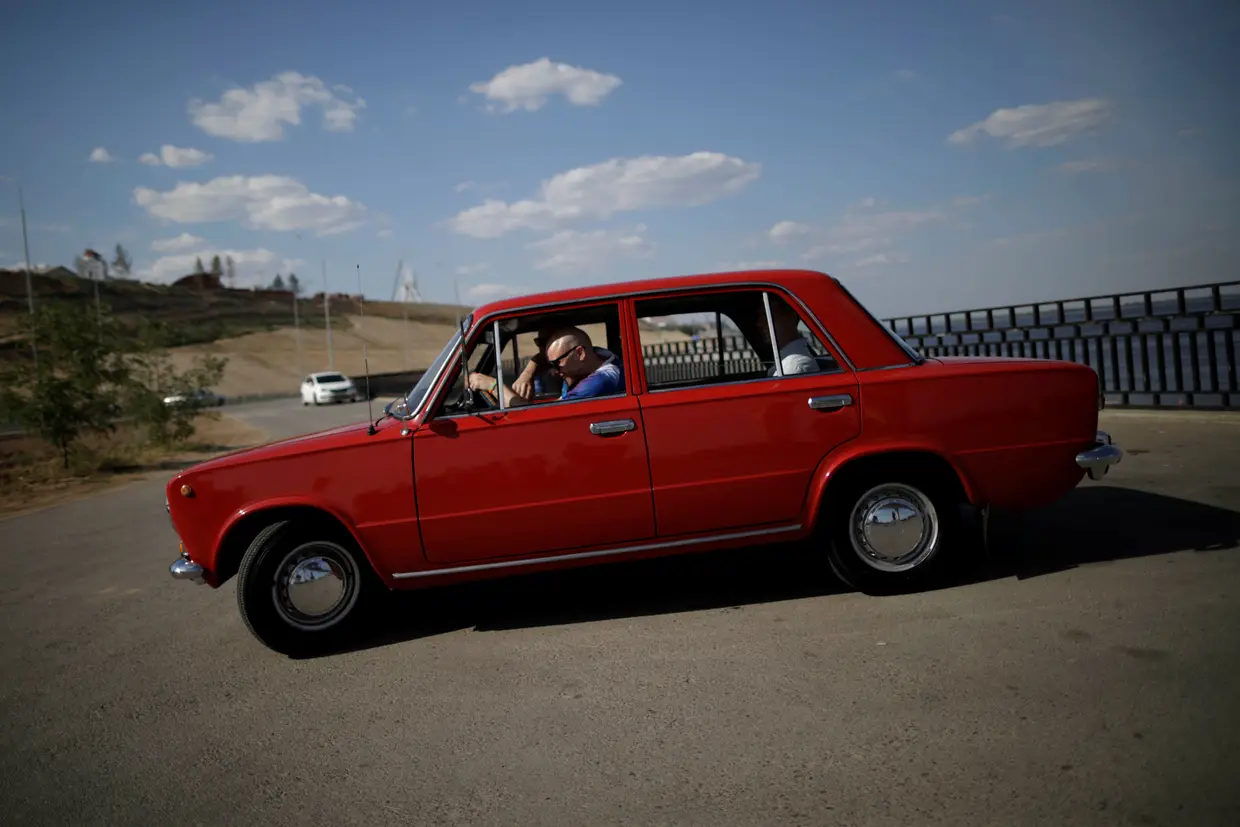 Adepto da Islândia em Volgograd ao volante de um Lada, num modelo que faz lembrar o regime soviético.