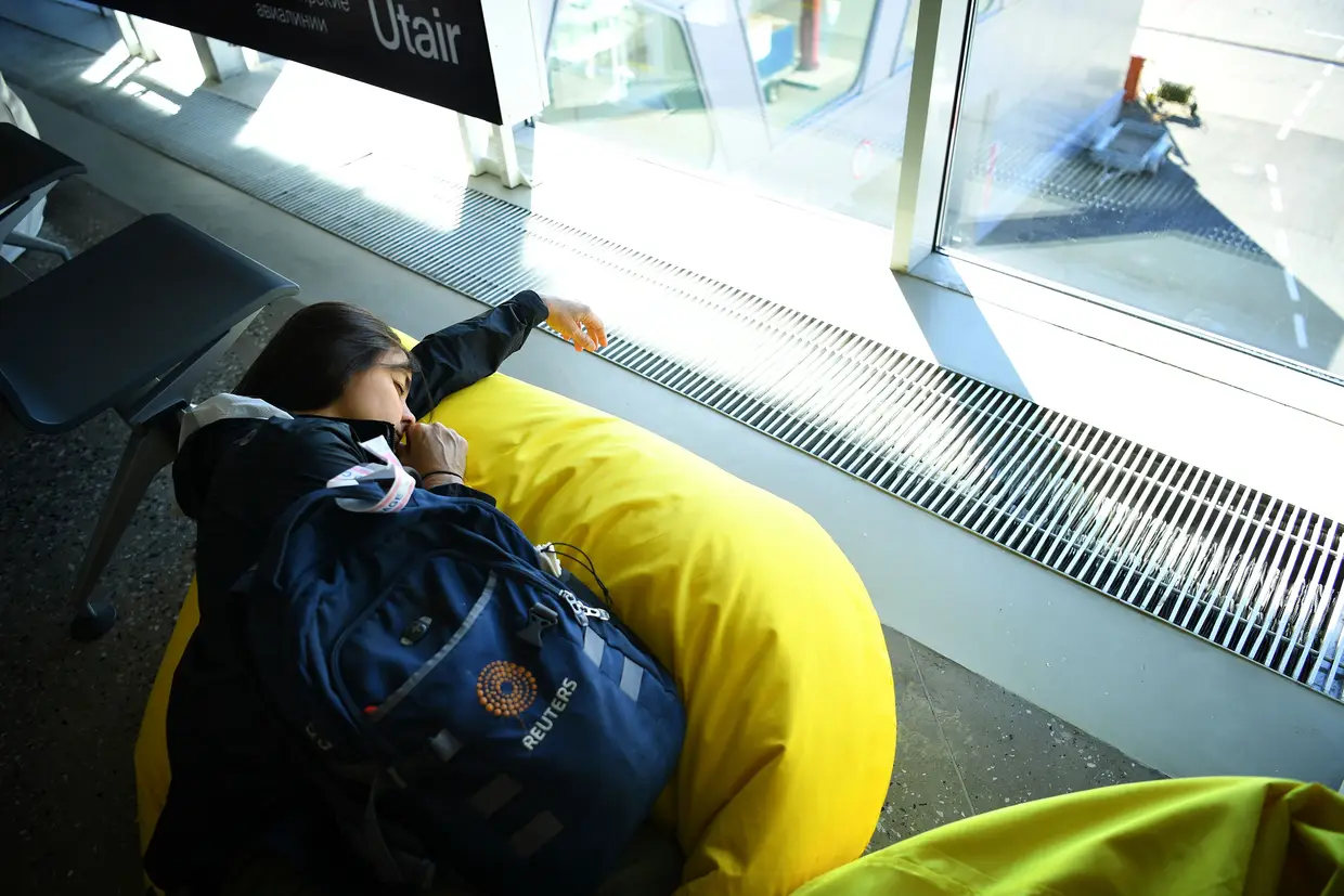 Repórter fotográfica descansa no Aeroporto Kurumoch enquanto espera pelo primeiro voo.