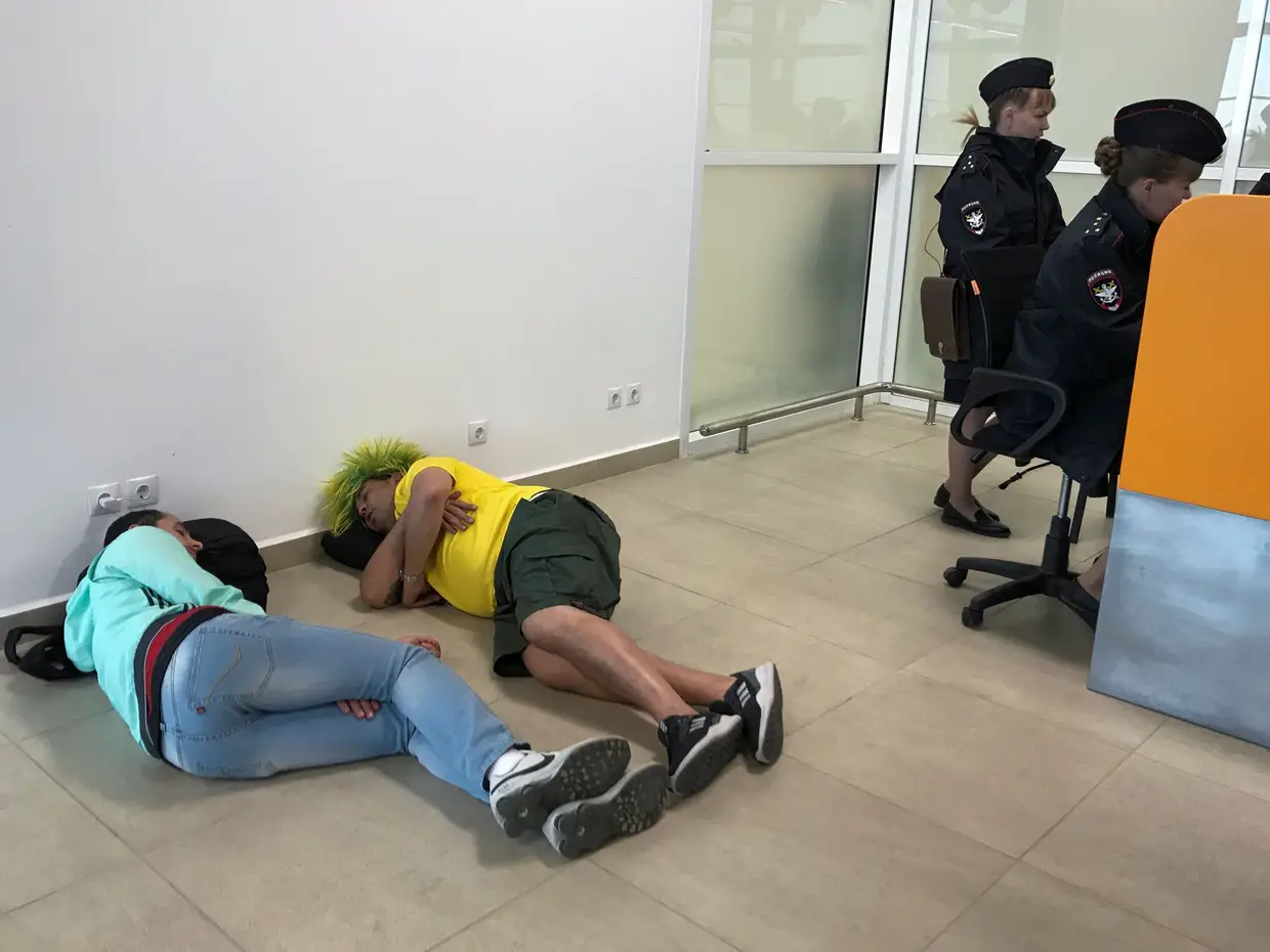 Adeptos do Brasil descansam ao lado de posto de segurança do aeroporto de Volgograd.