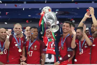 Nani entre Fernando Santos que ergue a taça de Campeão Eurropeu e Pepe
