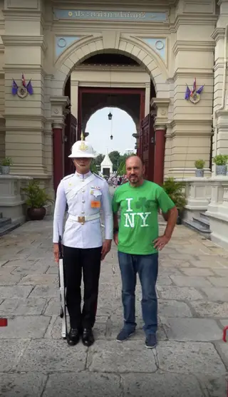 Cajuda na Tailândia, ao lado de um polícia
