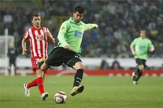 Saleiro em ação, sob o olhar de Simão Sabrosa, nm jogo dos quartos de final da Liga Europa, com o Atlético de Madrid, na época 2010-11