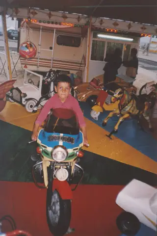 Rony na mota de um carrocel de feira