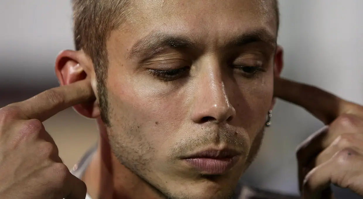 É uma das imagens de marca de Valentino Rossi: os dedos nos ouvidos no momento de se concentrar. A foto é do GP Qatar de 2007