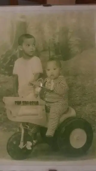 Rolando, no mini trator, com um dos tios que considera irmãoi