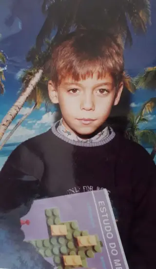Nuno Pinto, com o livro de estudo do meio, na primária