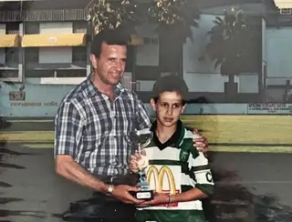 A receber um troféu das mãos de Nené