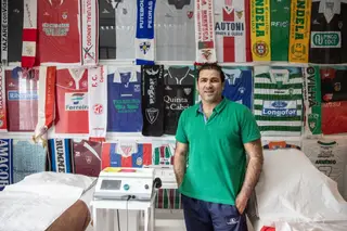 João no seu gabinete de massagens, onde tem expostas camisolas de futebol dos clubes onde jogou