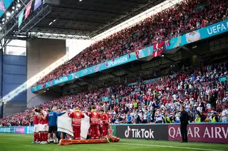 Os jogadores da Dinamarca e paramédicos a circundarem Christian Eriksen, durante as manobras de reanimação feitas no estádio Parken, em Copenhaga, após o jogador cair inanimado durante o Dinamarca-Finlândia