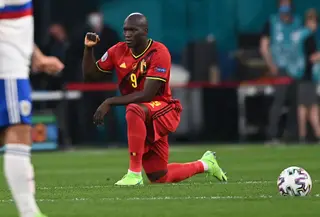 Lukaku ajoelha-se na Gazprom Arena, na Rússia, e ergue o punho, perante os assobios da claque russa