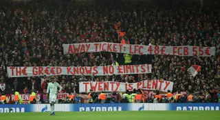 Um cartaz a criticar os bilhetes dos preços dos adeptos visitantes é mostrado pelos fãs do Bayern em Anfield, na Champions 2018/19