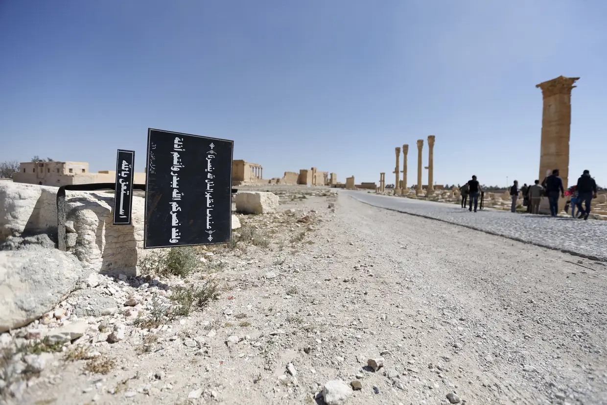 Cartaz com versículos do Corão em Palmyra, Síria.