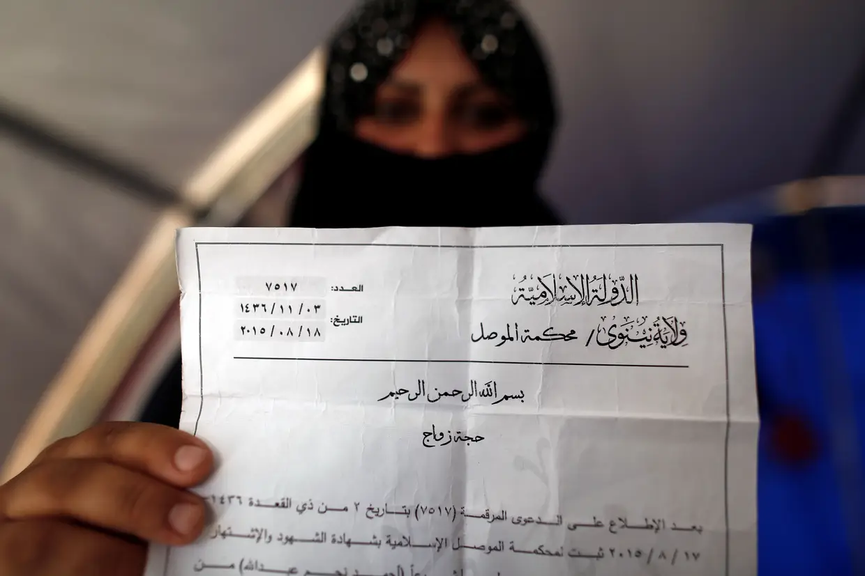 Uma mulher que fugiu de Mosul mostra a certidão de casamento emitida pelo Daesh mas que não é reconhecida pelas autoridades iraquianas.