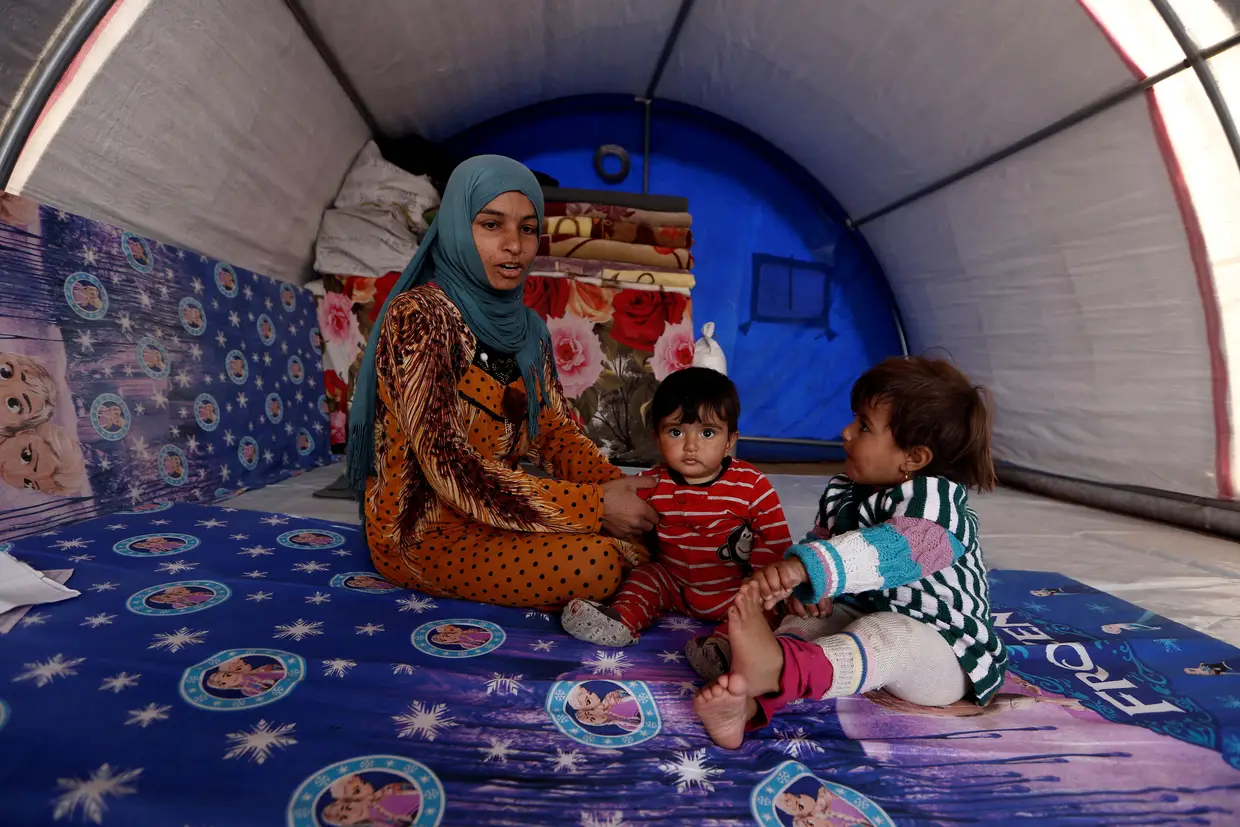 Nada, de 8 meses, e a irmã Houda, de 2 anos, com a mãe numa tenda no campo de refugiados de Khazer, no Iraque, depois de terem fugido do Daesh.