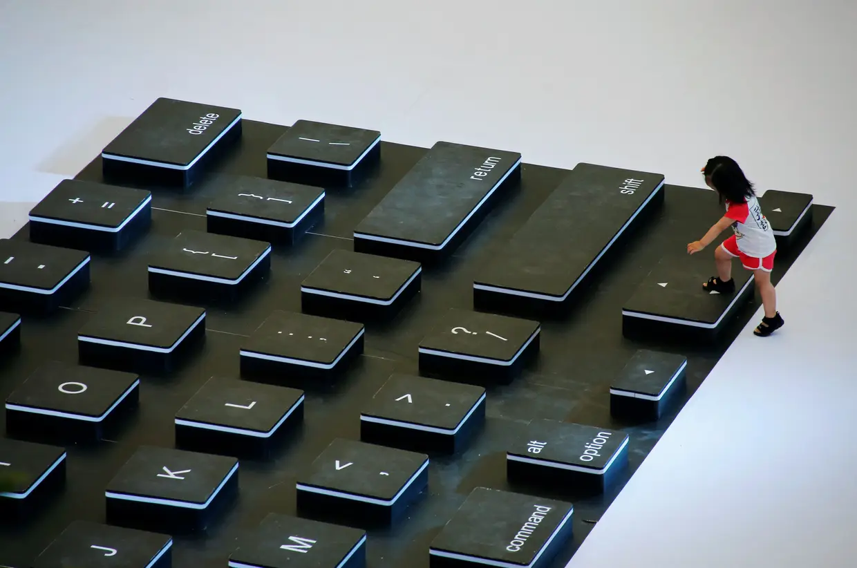 Uma criança chinesa caminha sobre um teclado gigante, numa ação promocional num centro comercial de Pequim.