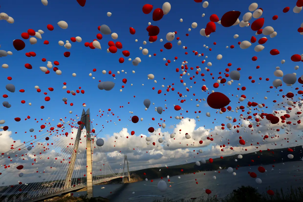 Balões vermelhos e brancos enchem o céu durante a inauguração da ponte Yavuz Sultan Selim, que liga os lados europeu e asiático de Istambul, na Turquia.