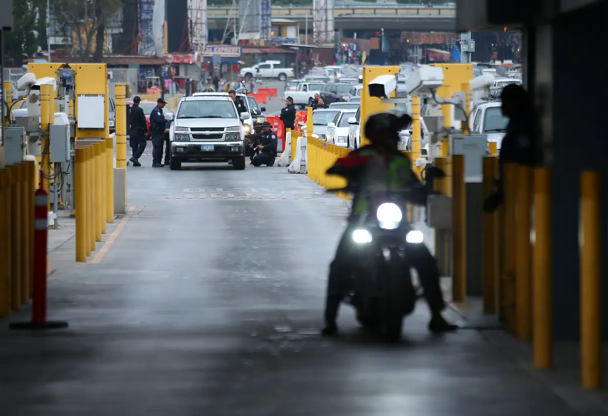A polícia inspeciona um veículo antes de passar a fronteira.