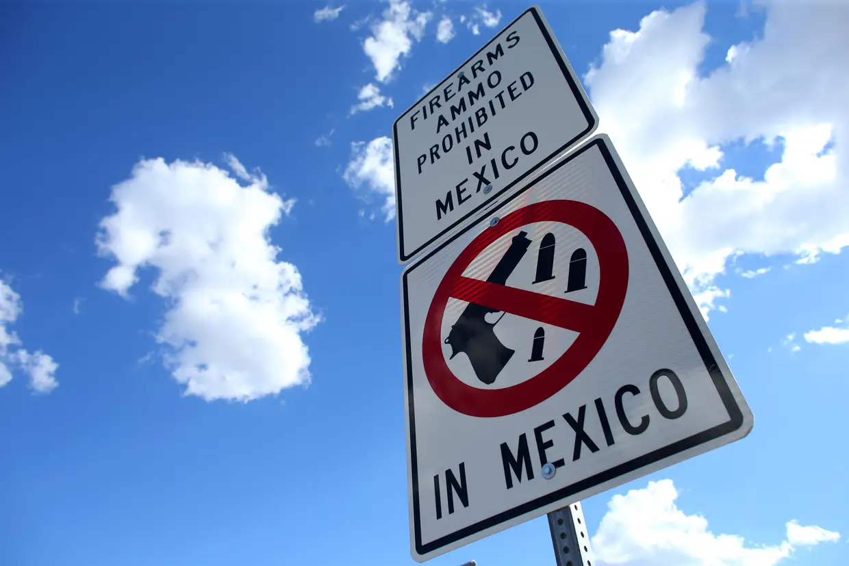 Um sinal que informa que armas de fogo e munição são proibidos no México. Fronteira de Nogales, Arizona.