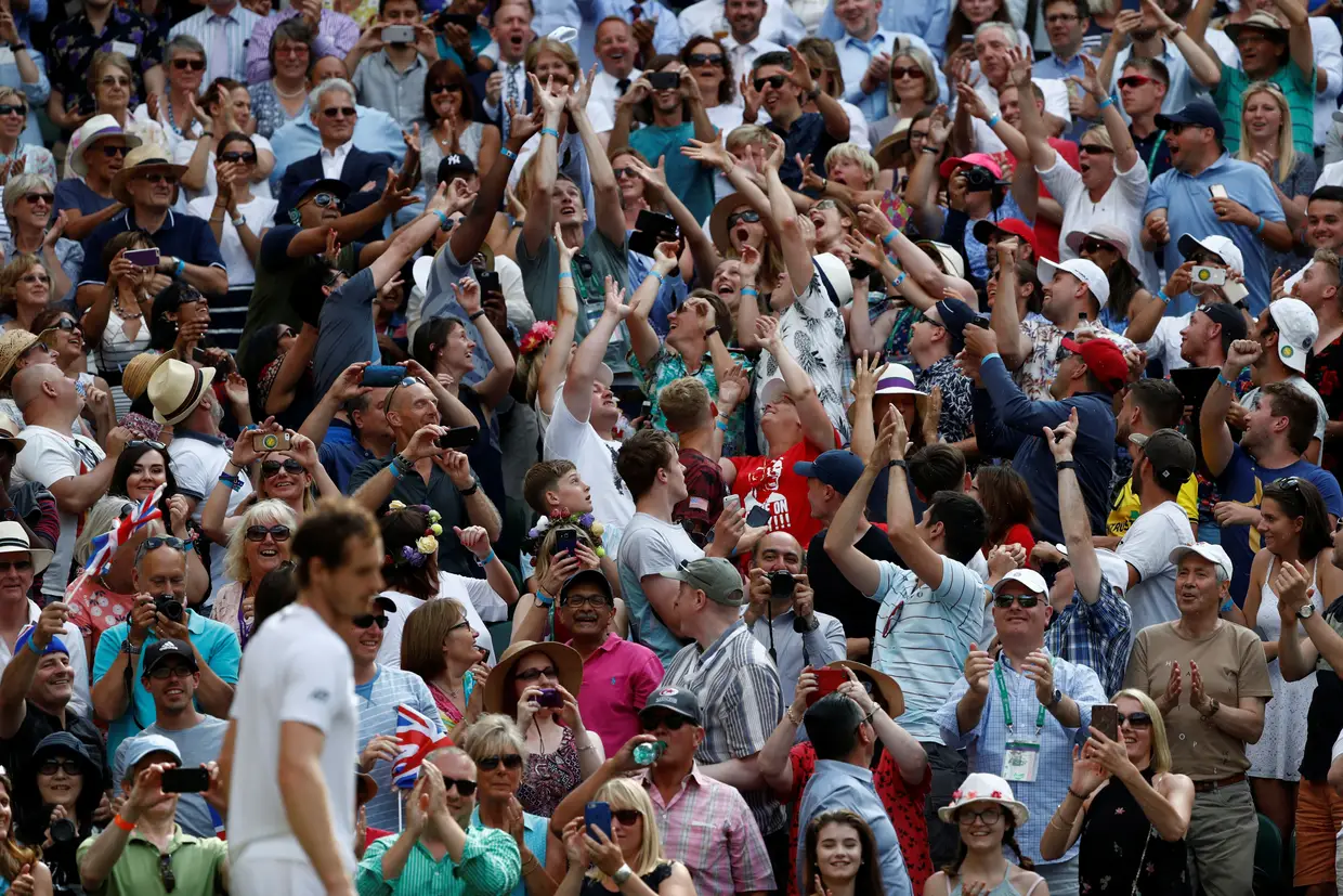 Andy Murray atira a sua fita para o público.