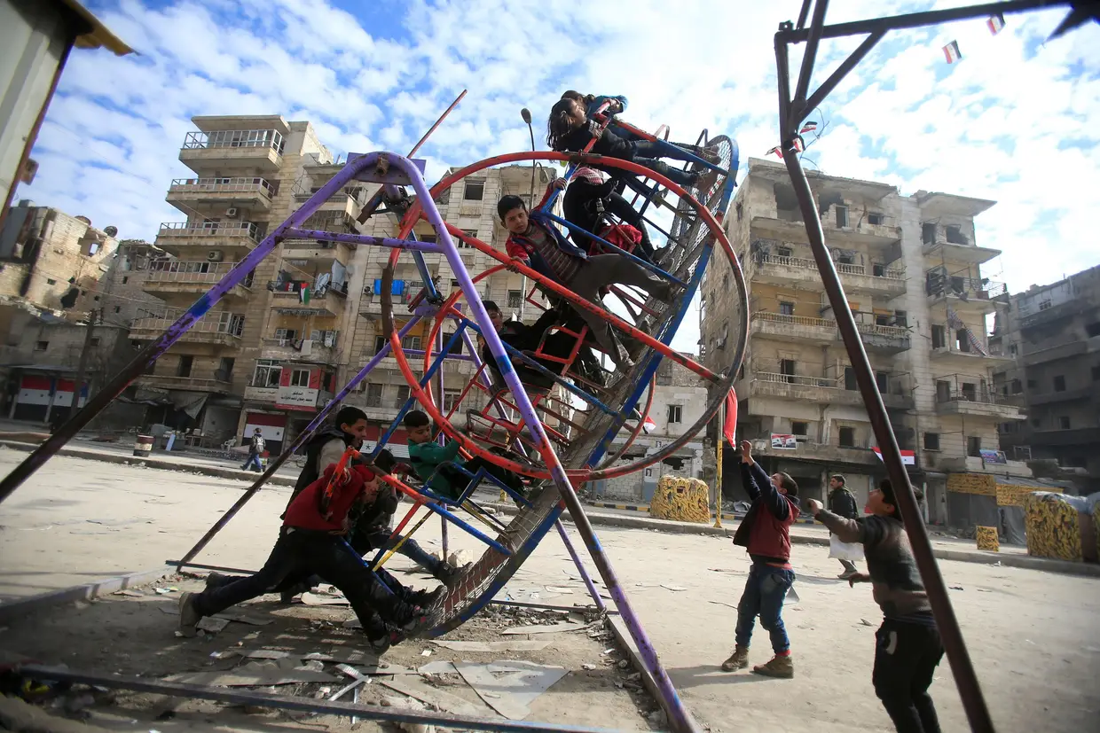 Janeiro - Crianças brincam no que resta de um espaço infantil em Aleppo, Síria.