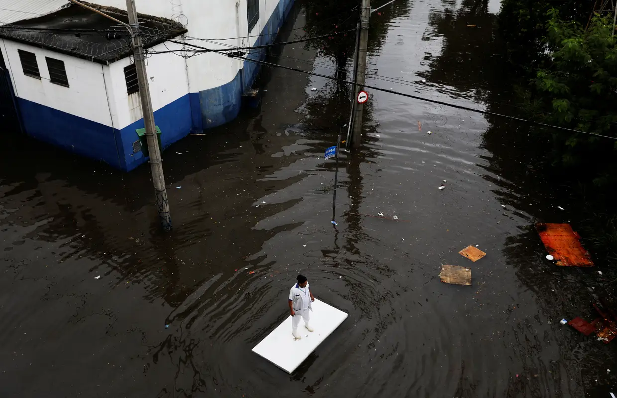 Abril - Uma mesa serve para navegar nas ruas inundadas de São Paulo, após as fortes chuvas que atingiram a cidade brasileira.
