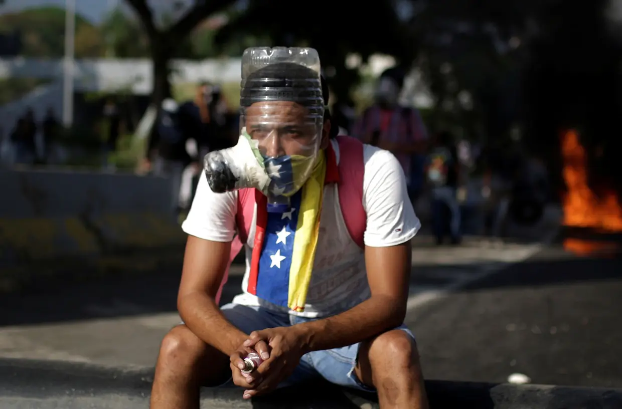 Abril - Manifestante com uma máscara improvisada para fazer se proteger das bombas de gás lacrimogéneo.