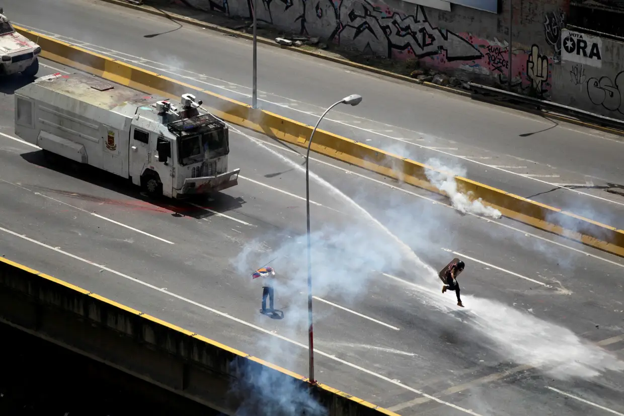 Maio - Manifestante apoiante da oposição atingido por um canhão de água em Caracas, Venezuela.
