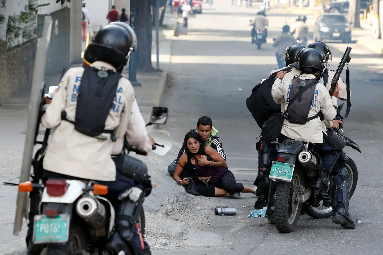 Julho - Homem segura nos braços uma mulher em pânico perante a ameaça das forças de segurança, durante um protesto contra o Presidente Nicolas Maduro em Caracas, Venezuela.