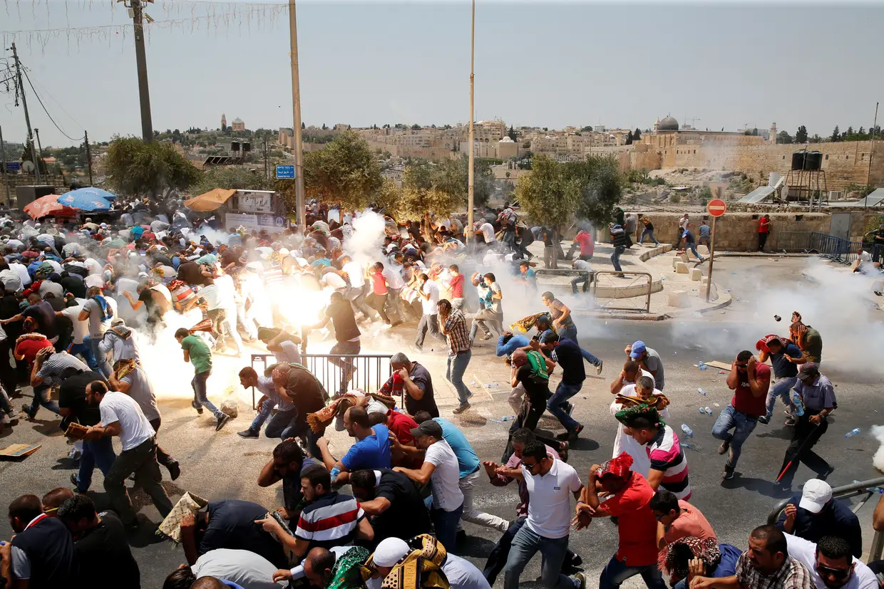 Julho - Palestinianos fogem das forças de segurança israelita que lançam bombas de gás lacrimogéneo para dispersar uma multidão que cumpria o ritual das orações de sexta-feira, nos arredores de Jerusalém.