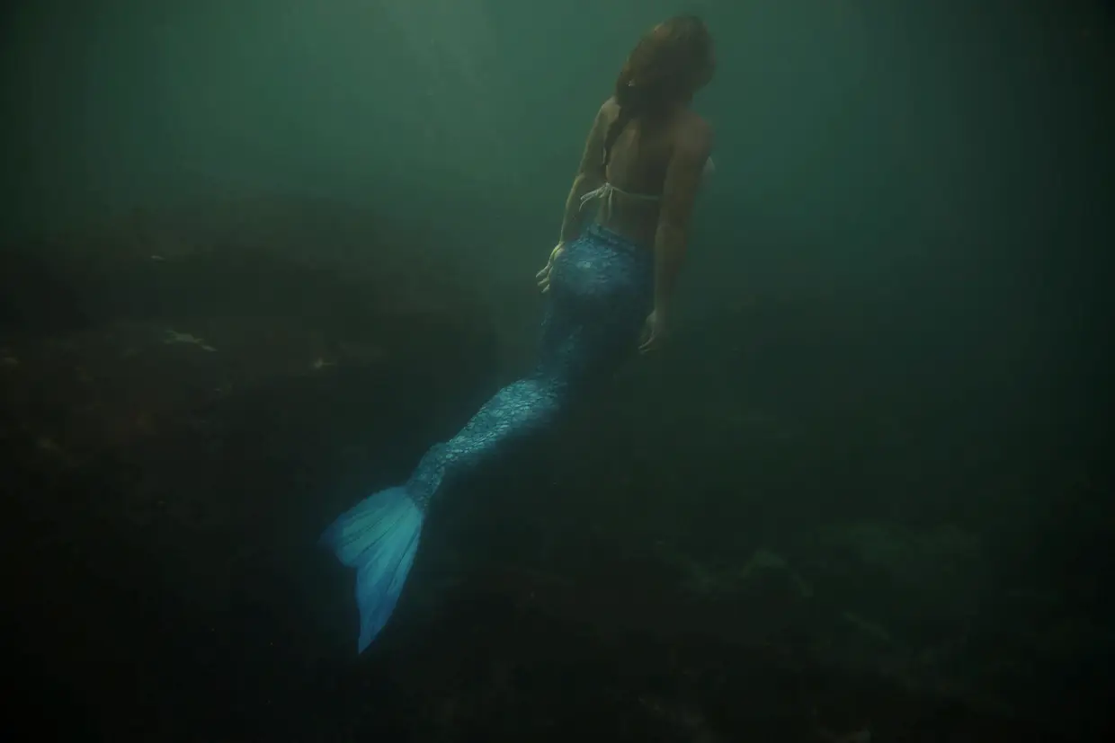 Instrutora de mergulho, Luciana Fuzetti, treina o uso de fato de sereia no mar ao largo das ilhas Tijucas,
