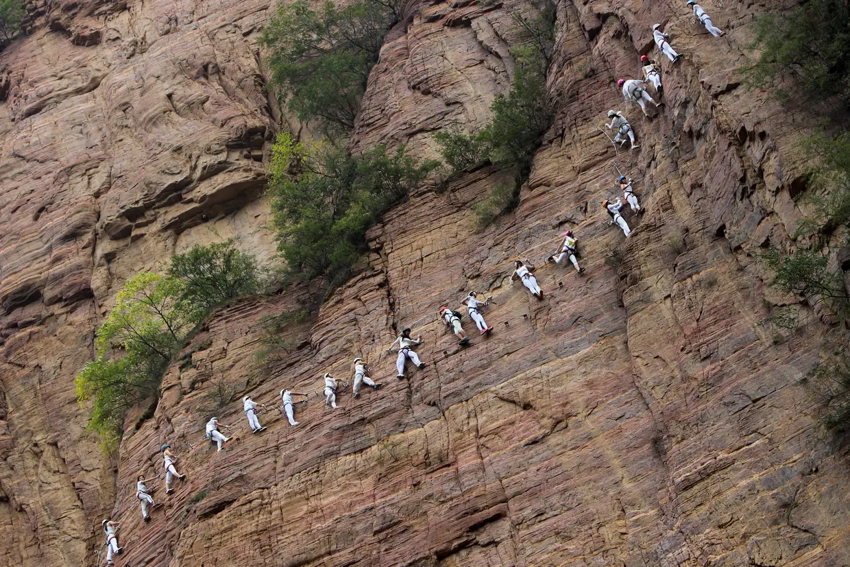 Alpinistas escalam uma montanha em Qingyao, na província de Henan, China.