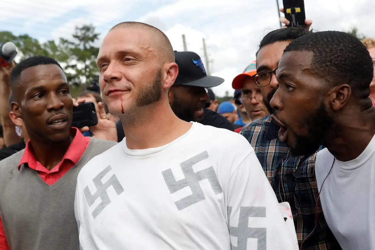 Outubro - Seguidor do movimento nacionalistas norte-americano assiste ao discurso do líder Richard Spencer, enquanto é alvo de insultos de manifestantes negros no campus universitário de Gainesville, Florida.