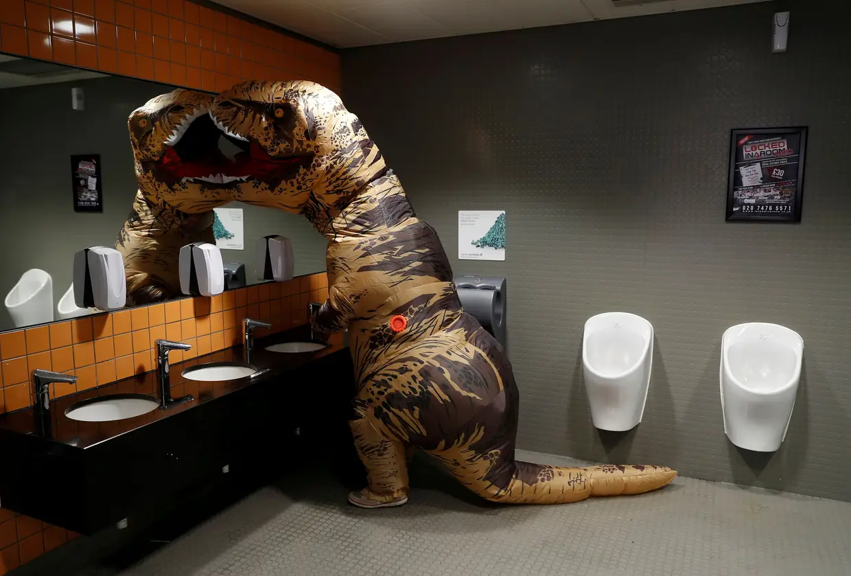 Um visitante vestido de T-Rex no WC da London Comic Con, evento realizado nos arredores da capital britânica.