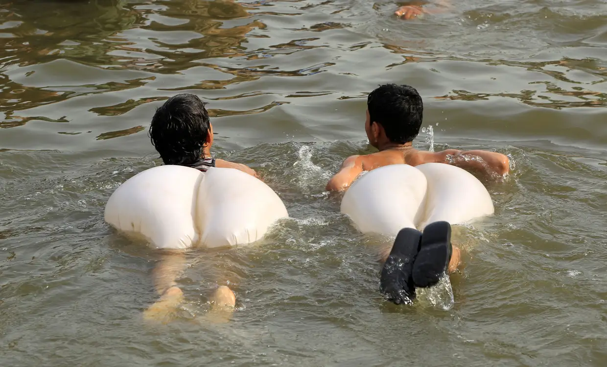 Rapazes refrescam-se num riacho durante uma vaga de calor em Islamabad, Paquistão.