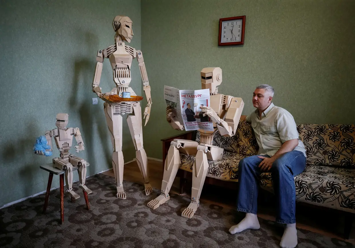 Dmitry Balandin posa para a fotografia com os modelos que criou em madeira no seu apartamento em Zaporizhzhya, Ucrânia.