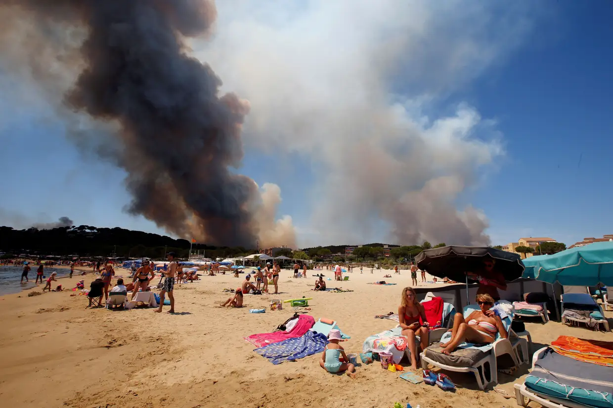 Julho - Incêndio florestal nas imediações de uma praia em Bormes-les-Mimosa. O fogo obrigou à retirada de 12 mil pessoas, na região da Riviera Francesa.