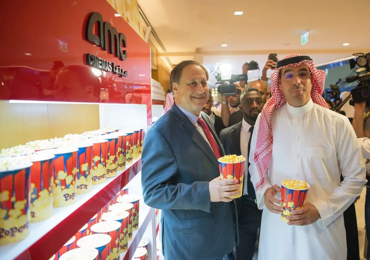 Uma foto divulgada pelo Ministério de Cultura e Informação da Arábia Saudita com Adam Aron, o CEO da AMC Entertainment, e o ministro saudita de Cultura e Informaçã,o Awwad Alawwad, rendidos às pipocas na inauguração do primeiro cinema público do Reino, no teatro King Abdullah Financial District (KAFD) em Riad, Arábia Saudita, a 18 de abril de 2018.