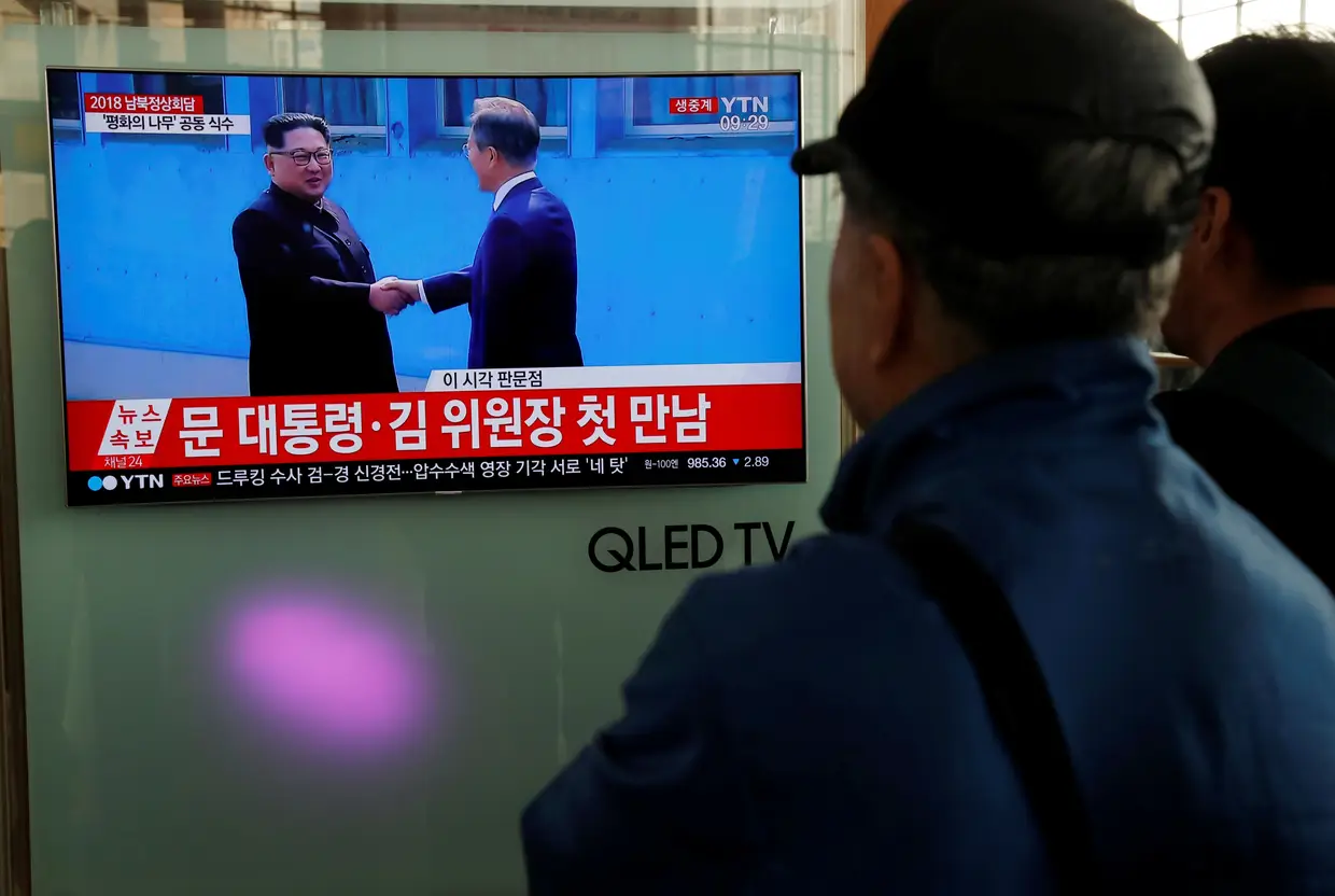 O encontro histórico entre os líderes das duas Coreias visto através da televisão em Seul.