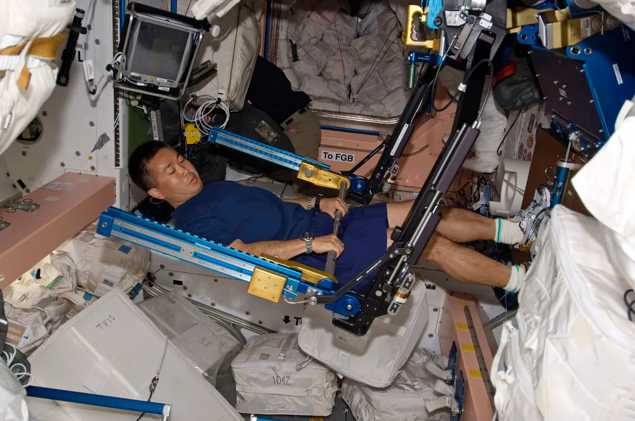 Astronauta japonês Koichi Wakata no ginásio onde osastronautas mitigam os efeitos da microgravidade, que os faz flutuar, exercitando os músculos durante duas horas diárias.