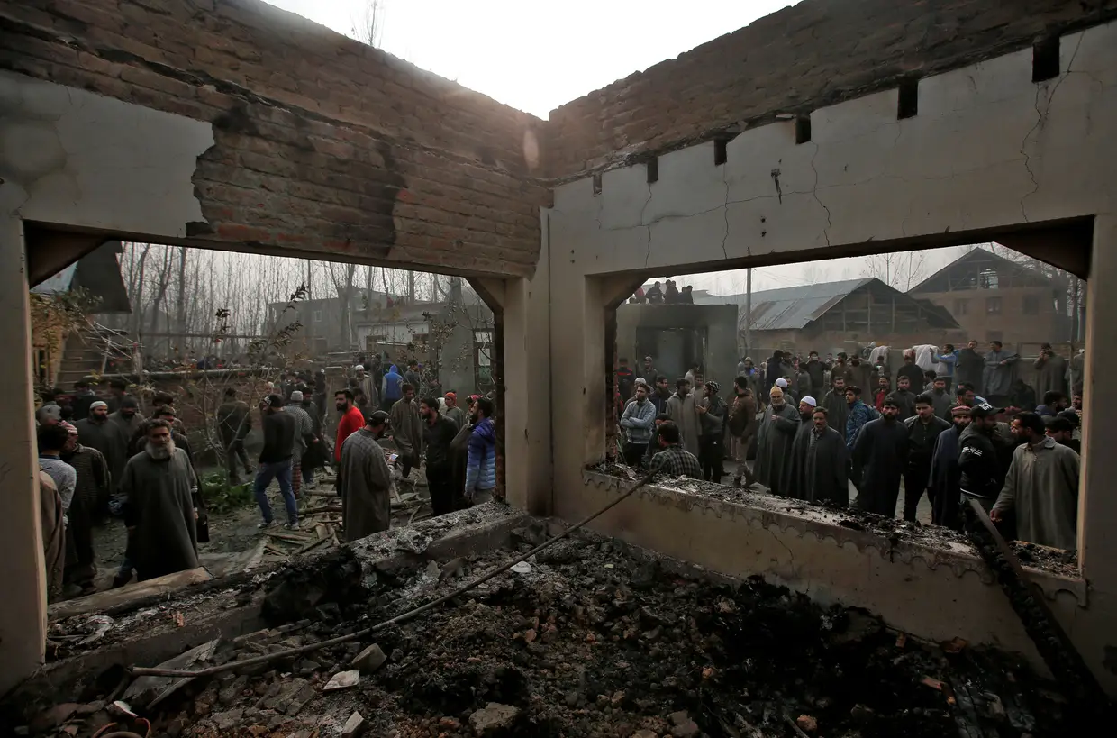 Vários curiosos visitam uma casa que terá sido destruída durante um tiroteio entre as forças de segurança indianas e milícias.