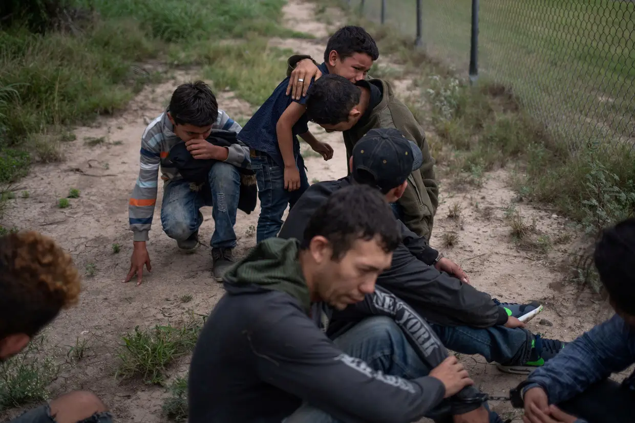Um menino de quatro anos chora por ter ficado retido na fronteira entre o México e os Estados Unidos, juntamente com familiares.