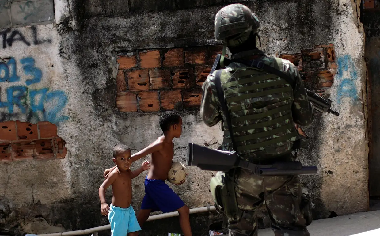 Uma criança olha para um militar brasileiro que está a participar numa operação contra o tráfico de droga nas favelas do Rio de Janeiro.