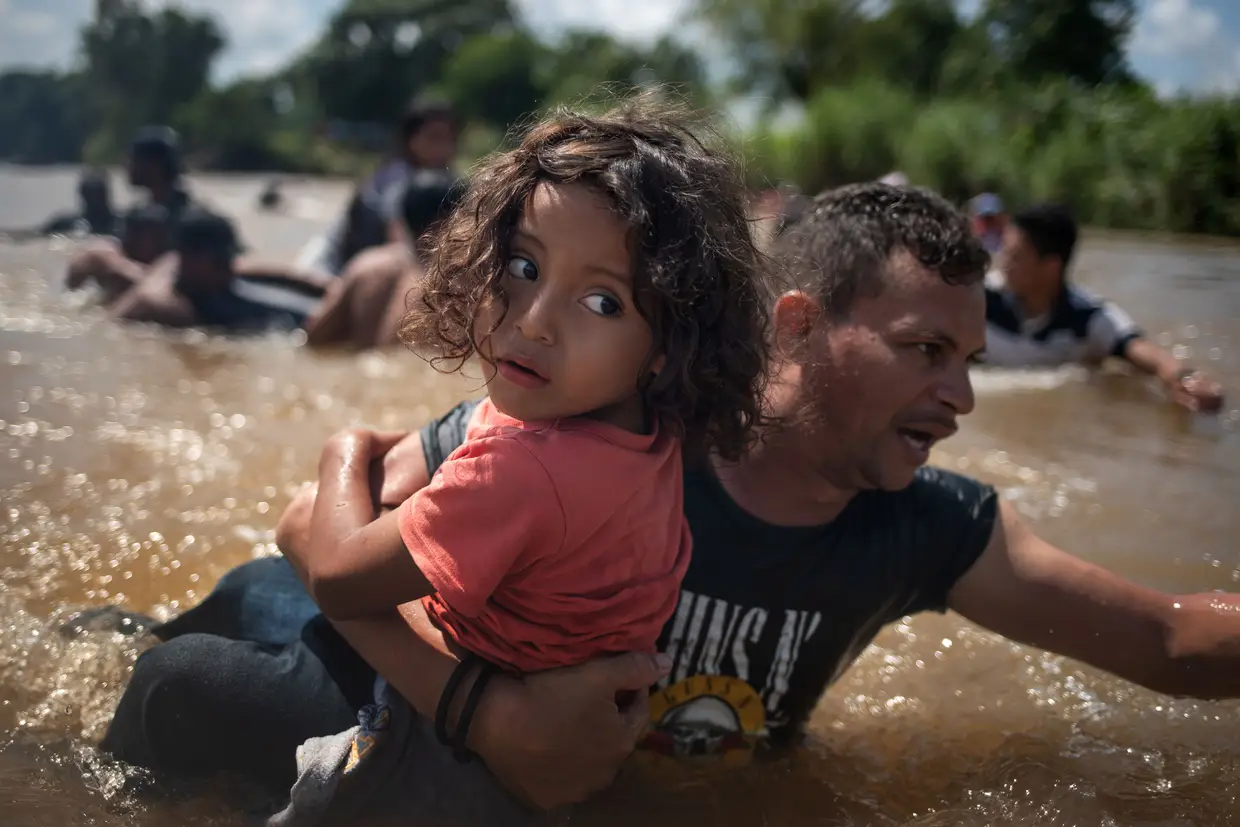 Luis Acosta segura bem a filha de 5 anos Angel Jesus, ambos das Honduras, para atravessarem o rio Suchiate entre a Guatemala e o México.